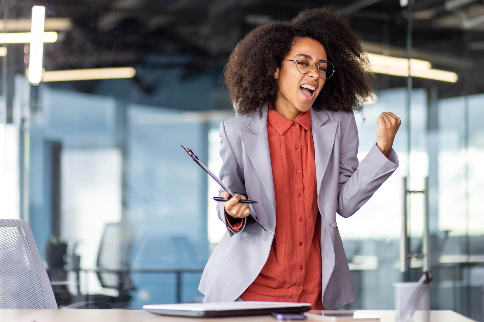 TV presenter in formal wear makes music gesture at event