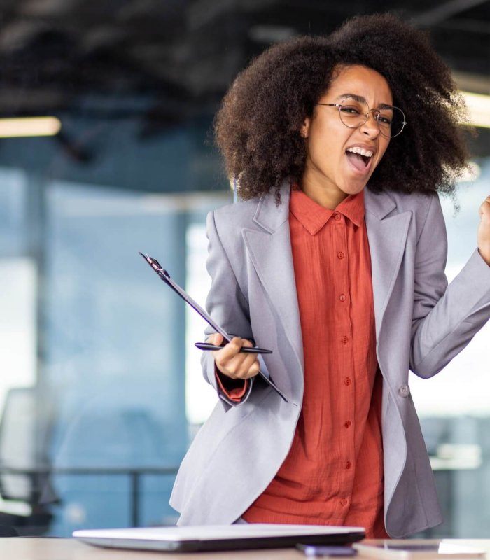 TV presenter in formal wear makes music gesture at event
