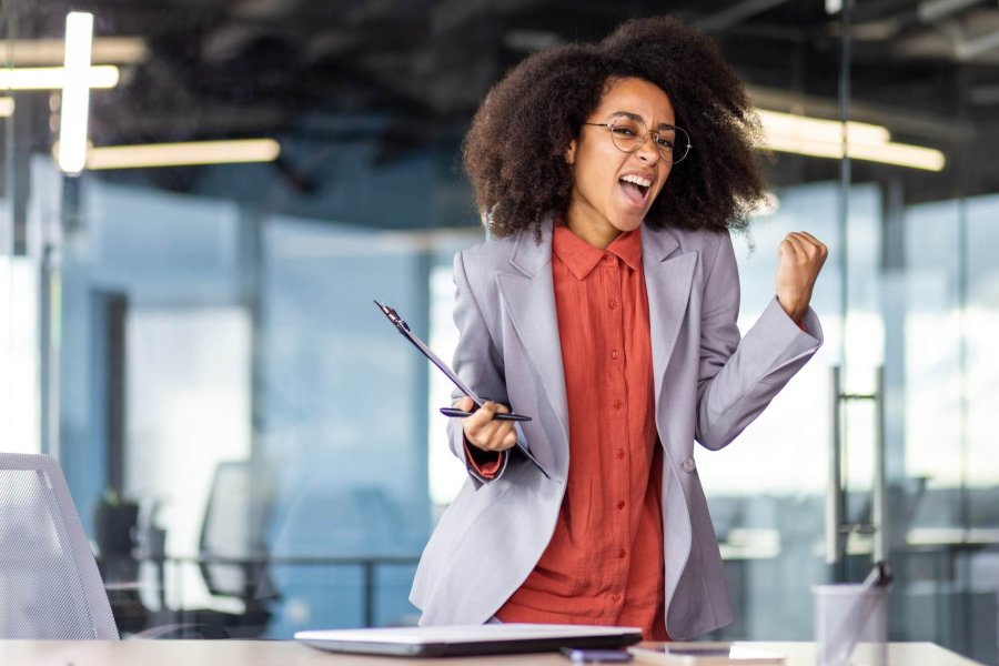 TV presenter in formal wear makes music gesture at event